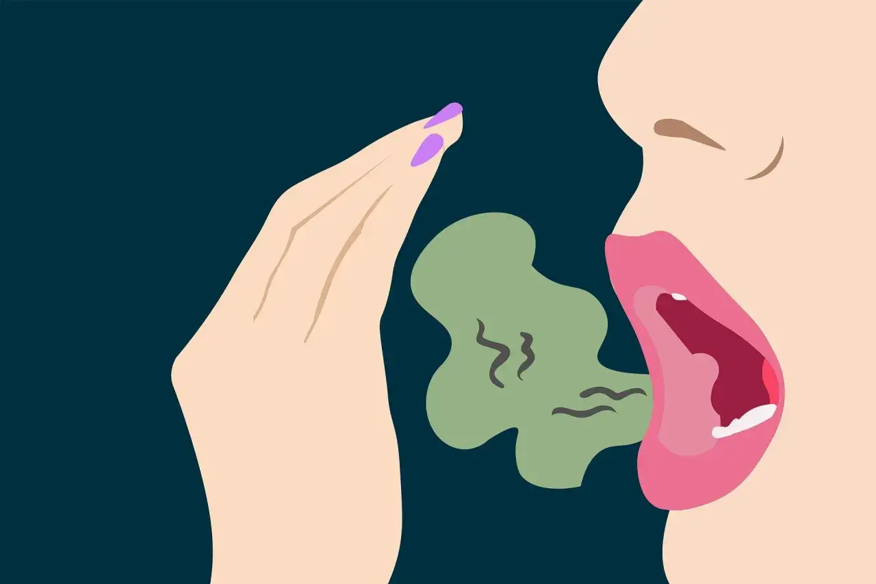 Una mano cubre la boca abierta de una persona, de la que emana una nube verde con rizos, indicando c&oacute;mo saber si me huele el aliento.
