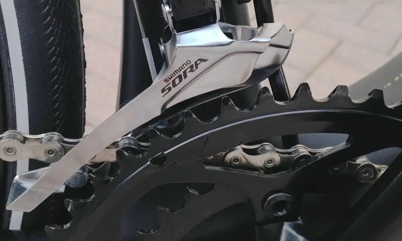 Precyzyjna regulacja przedniej przerzutki Shimano Sora, kluczowa dla płynnej zmiany biegów.