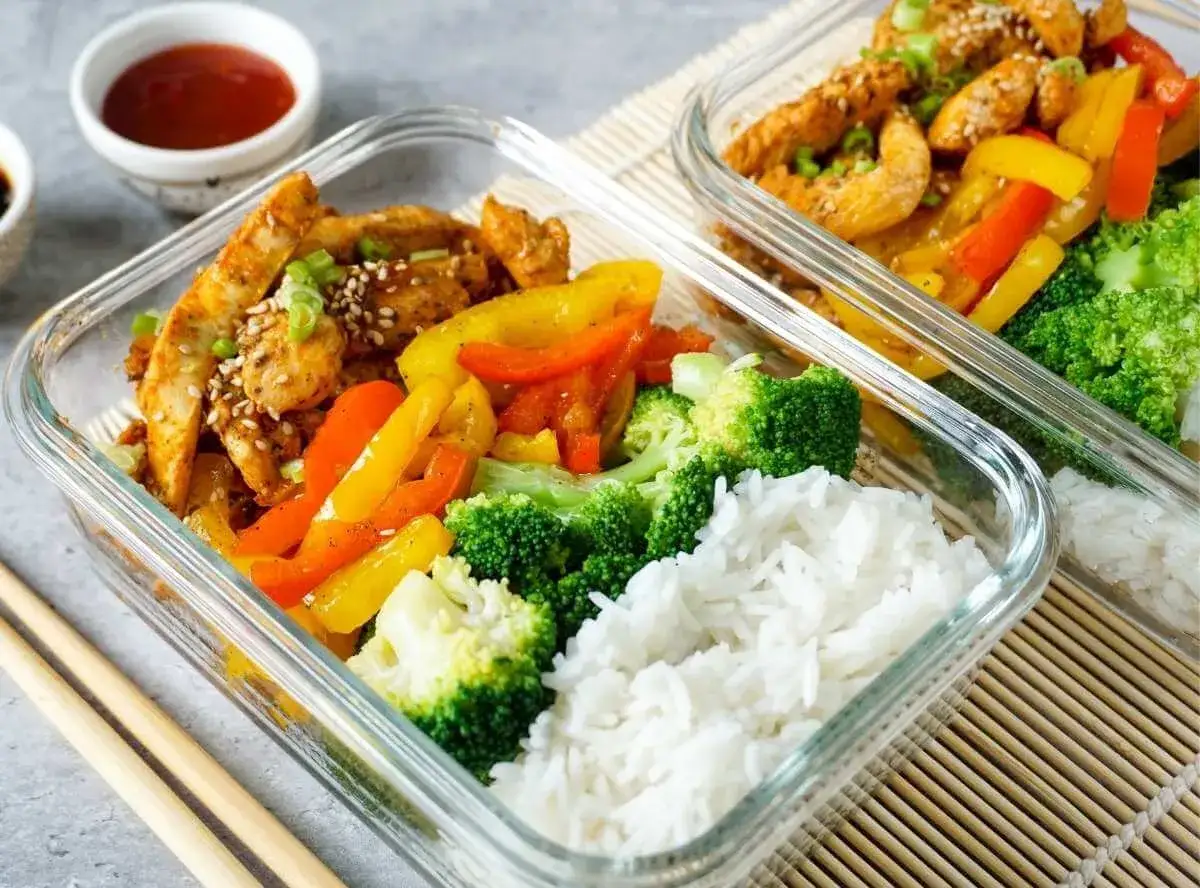 Gesunde meal prep rezepte: Hähnchen mit Paprika, Brokkoli und Reis in Glasbehältern. Perfekt für unterwegs!