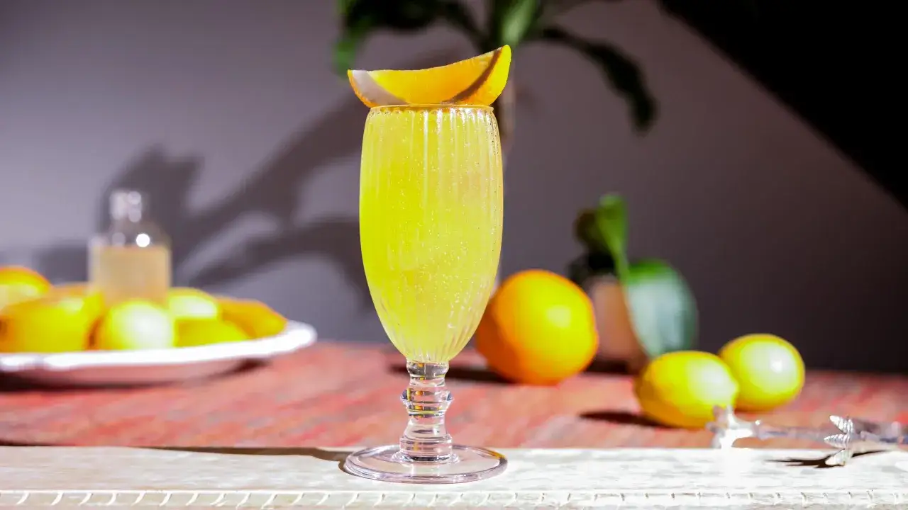 En bubblig, gul drink med apelsinskiva toppas. Perfekt f&ouml;r sommarens vodka drinkar.