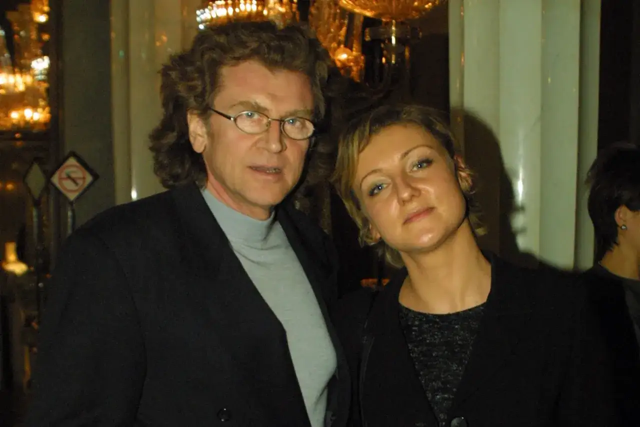 Zofia Czernicka i Wodecki w eleganckich strojach, pozują do zdjęcia w blasku świateł.