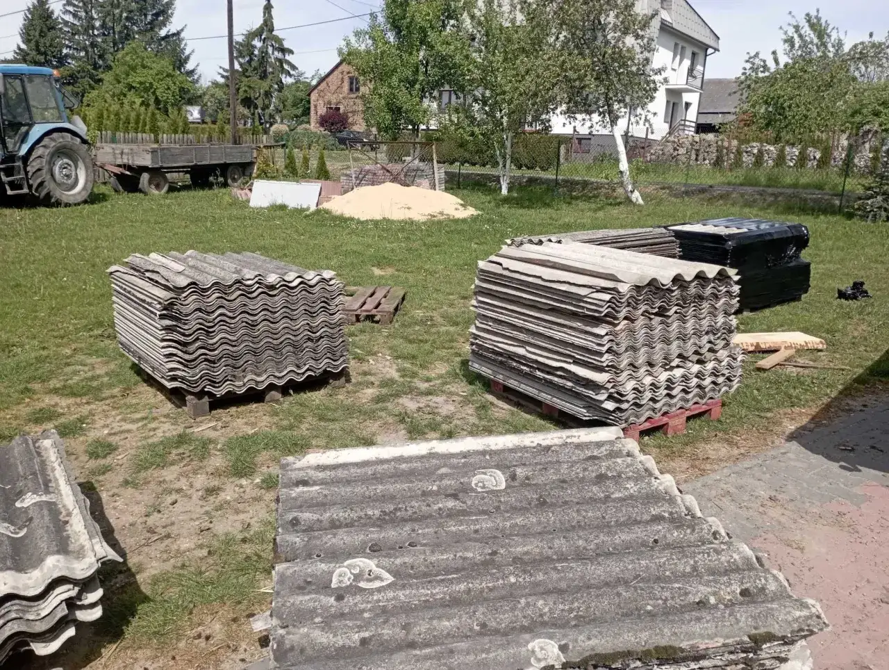 Składowanie eternitu na posesji. Stare eternitowe płyty dachowe czekają na utylizację.