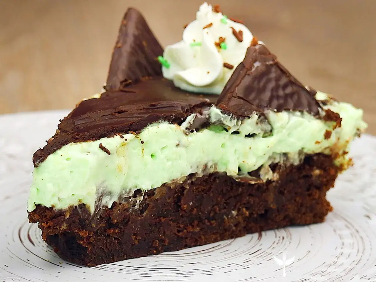 Ein Stück After Eight Kuchen mit Schokoladenboden, Minzcreme und Schokostückchen.