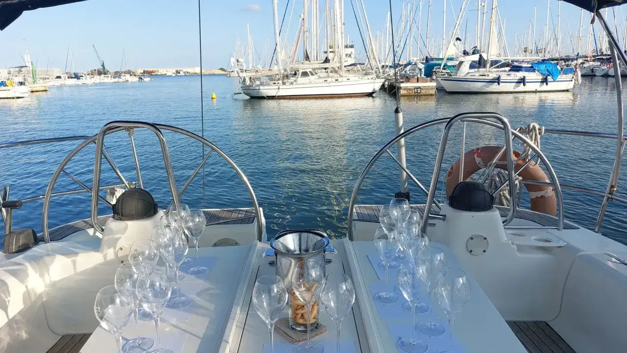 Copas de champán y aperitivos listos en un velero, ideal para ofertas de vacaciones en agosto.