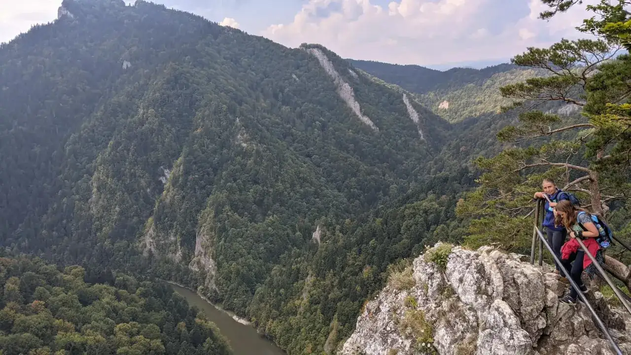Dwie turystki podziwiają malowniczy widok na przełom Dunajca i góry, w tym Trzy Korony ze Szczawnicy.