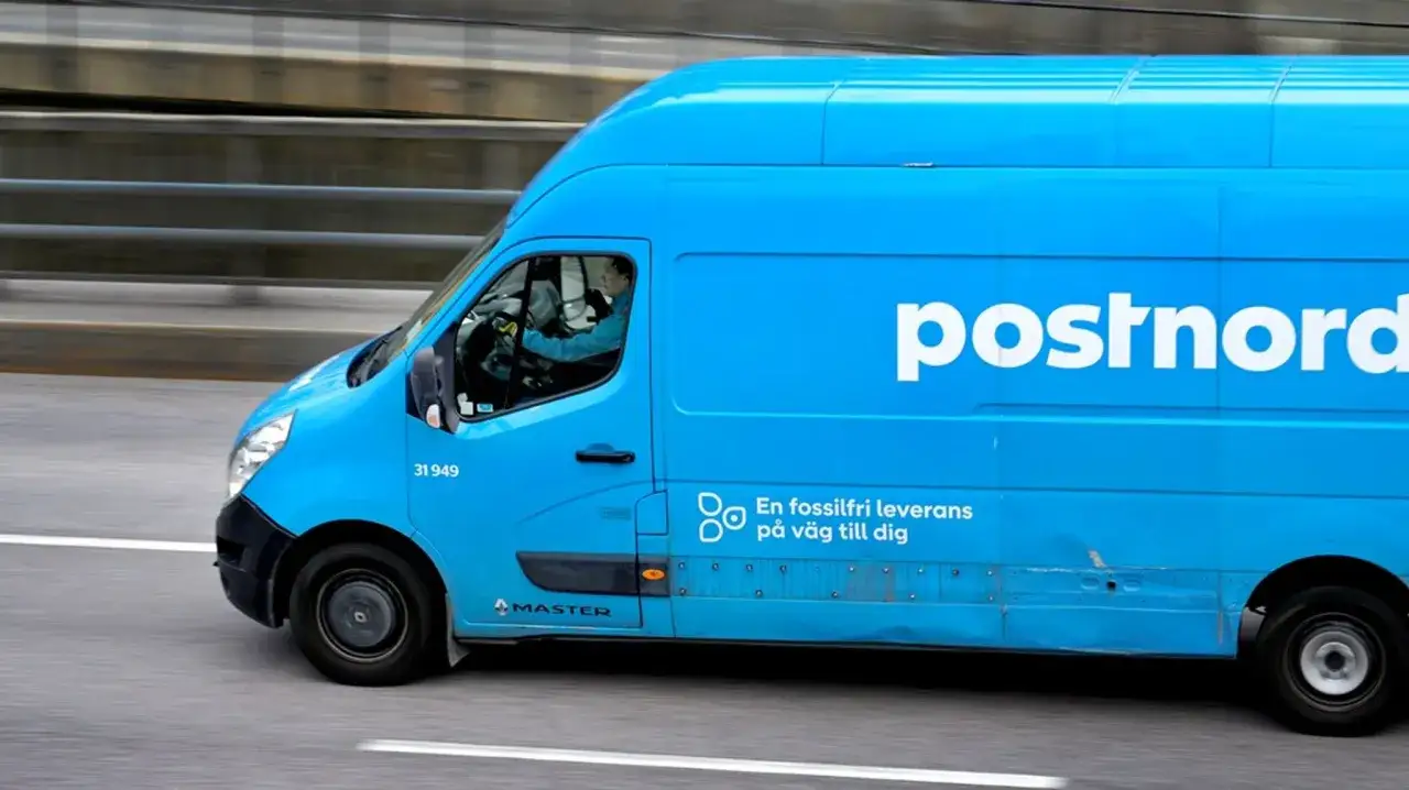En bl&aring; PostNord-sk&aring;pbil k&ouml;r p&aring; motorv&auml;gen, redo f&ouml;r postutdelning varannan dag.