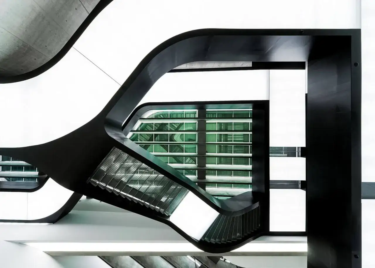 Interni del MAXXI - Museo nazionale delle arti del XXI secolo, con le sue iconiche curve nere e la facciata verde a griglia.