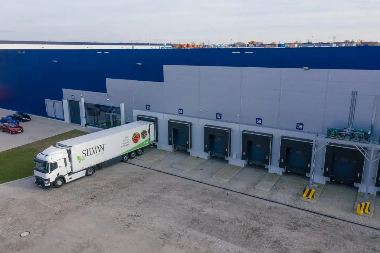 Ciężarówka z logo Silvan Logistics przy doku magazynowym. Sprawna spedycja transport krajowy to podstawa.