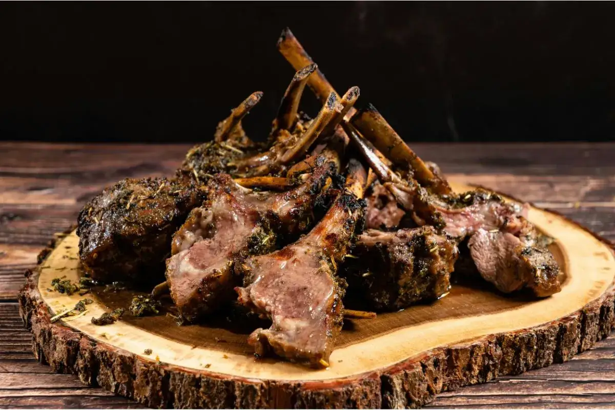 Carré d'agneau rôti, parfumé aux herbes, prêt à être dégusté. Le temps de cuisson de cette côtelette d'agneau est parfait.