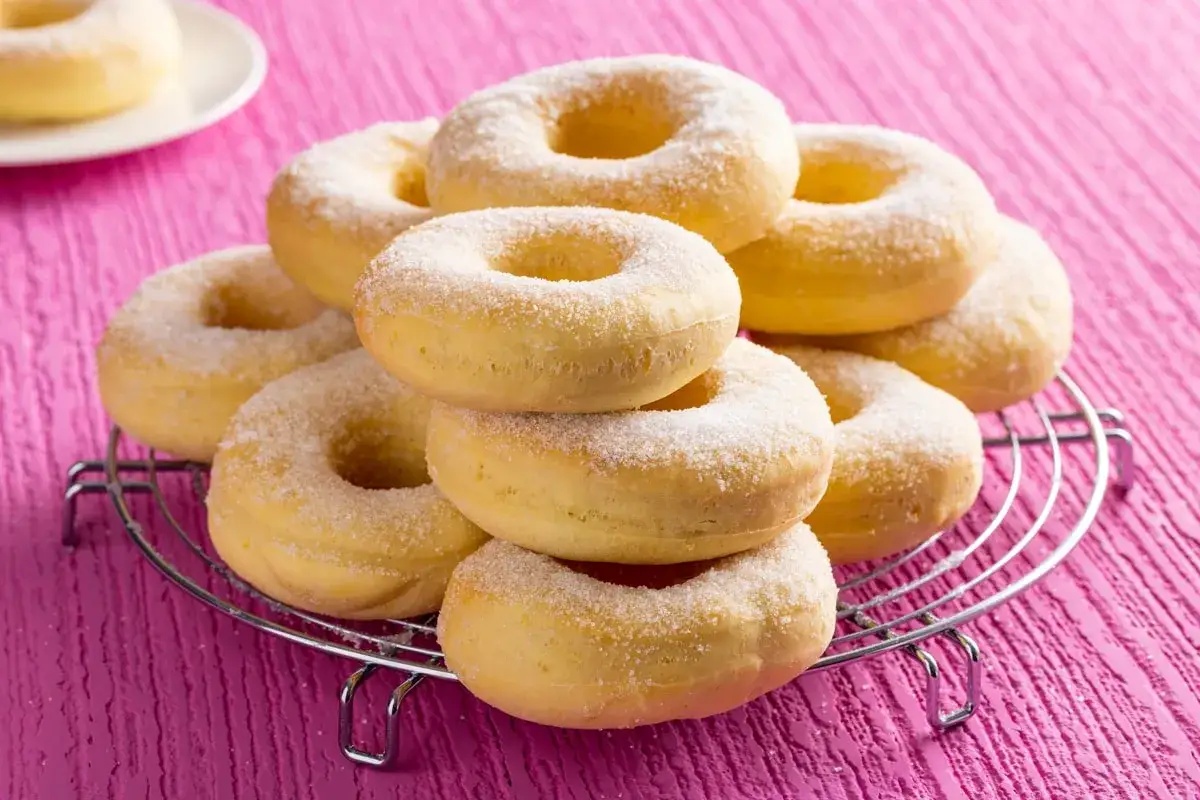 Dolci in friggitrice ad aria, una pila di ciambelle dorate cosparse di zucchero, pronte per essere gustate.