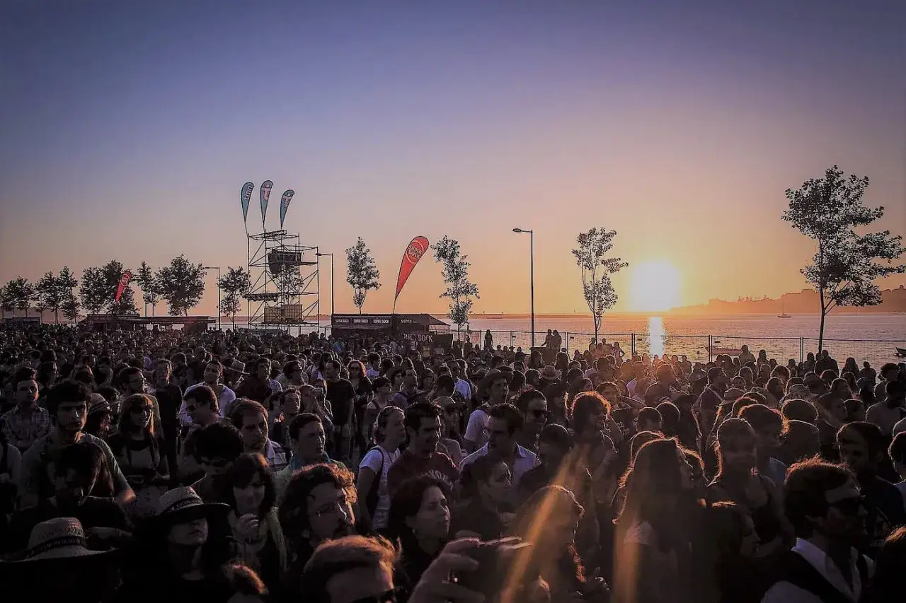 Folla di gente attende il tramonto durante un festival in Portogallo.