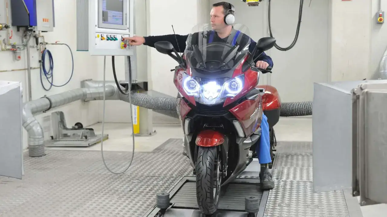 Mechanik w słuchawkach przeprowadza przegląd motocykla na hamowni.