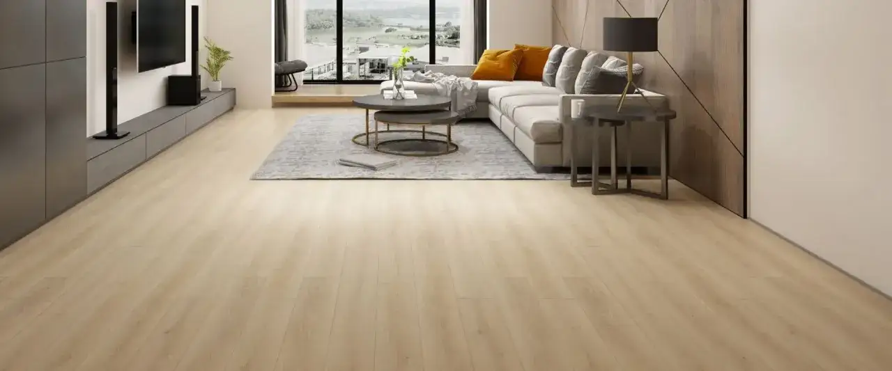 Amplio sal&oacute;n moderno con suelo de pavimento SPC de madera clara, sof&aacute; gris, mesas de centro y ventana con vistas.