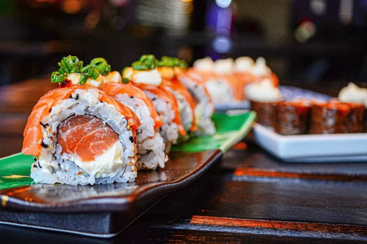 Pyszne rolki sushi z łososiem i kremowym serkiem, posypane szczypiorkiem. Czy sushi to zdrowe? Zdecydowanie tak, jeśli wybierasz świeże składniki!