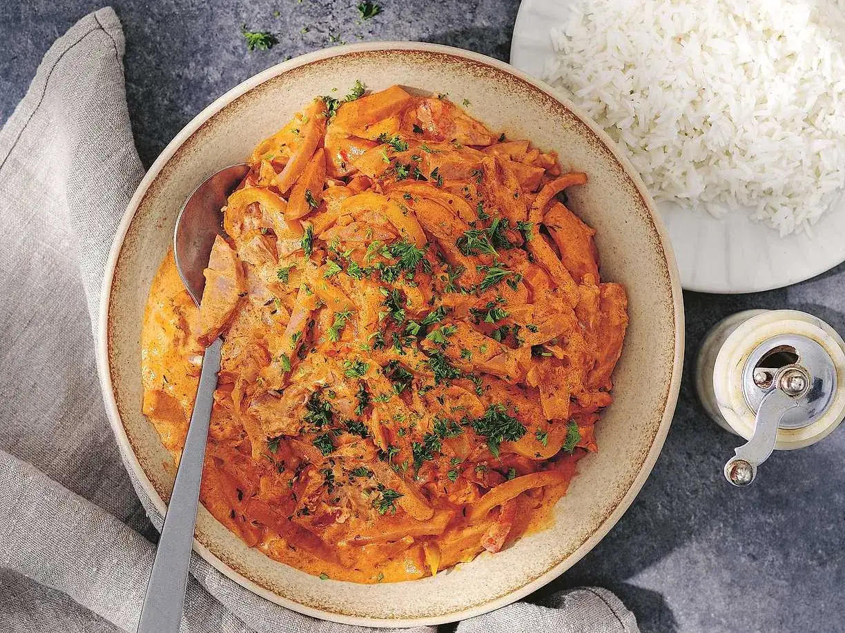 En krämig korvgryta, perfekt för ett snabbt och gott korvgryta recept. Serveras med fluffigt ris och toppas med färsk persilja.