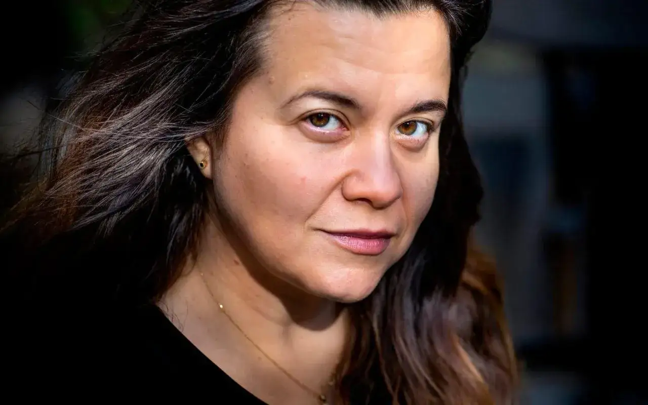 Caroline Ringskog Ferrada-Noli med sitt mörka hår och bruna ögon, bär ett guldfärgat halsband.