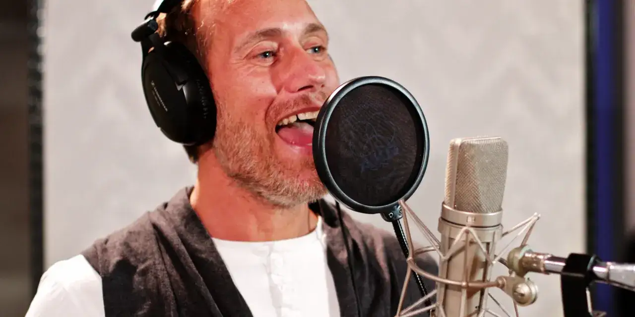 Man med h&ouml;rlurar spelar in en radioteater deckare.