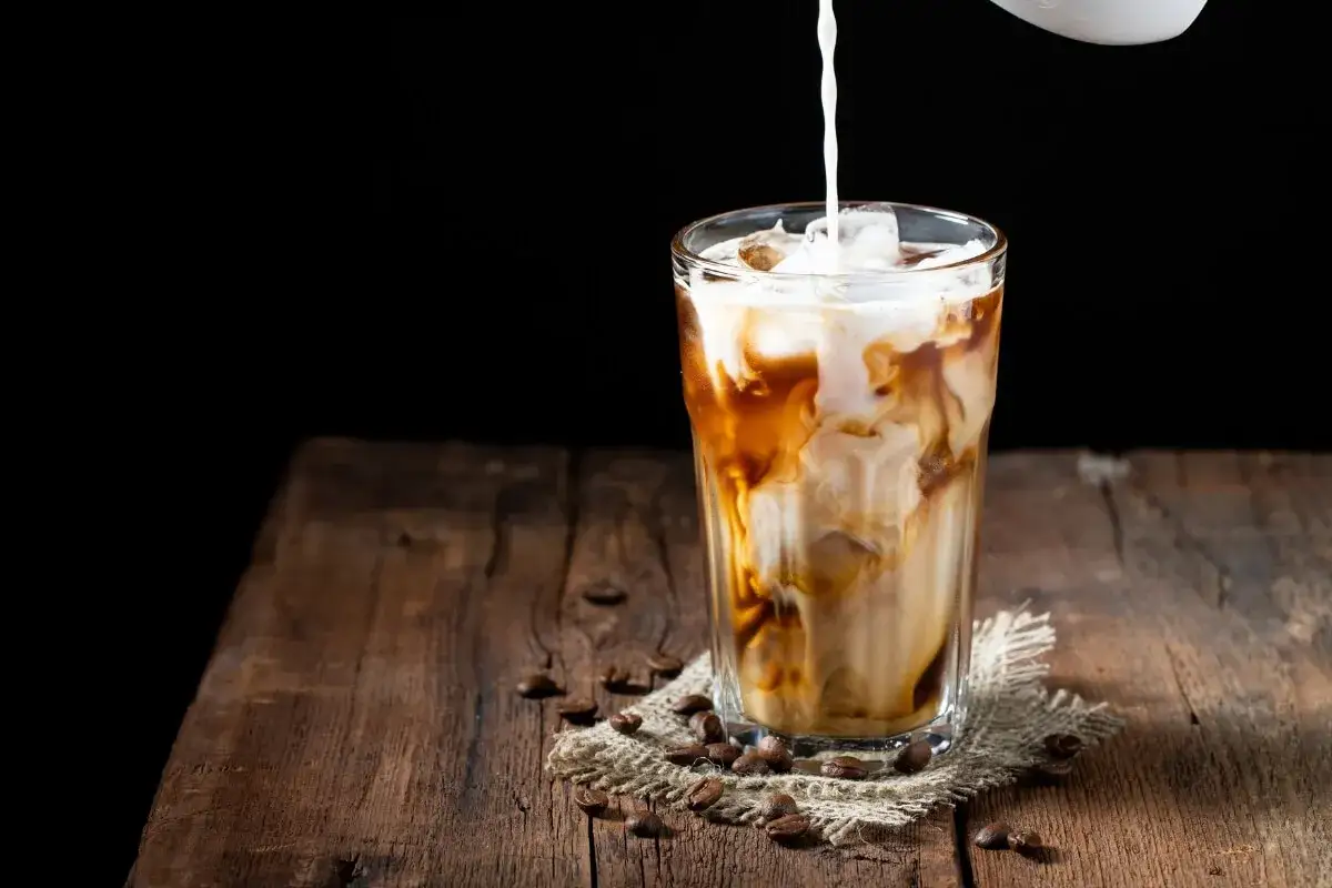 Ein erfrischender Eiskaffee mit Milch wird in ein Glas gegossen. Perfekt für die Schwangerschaft, wenn man Lust auf etwas Besonderes hat.