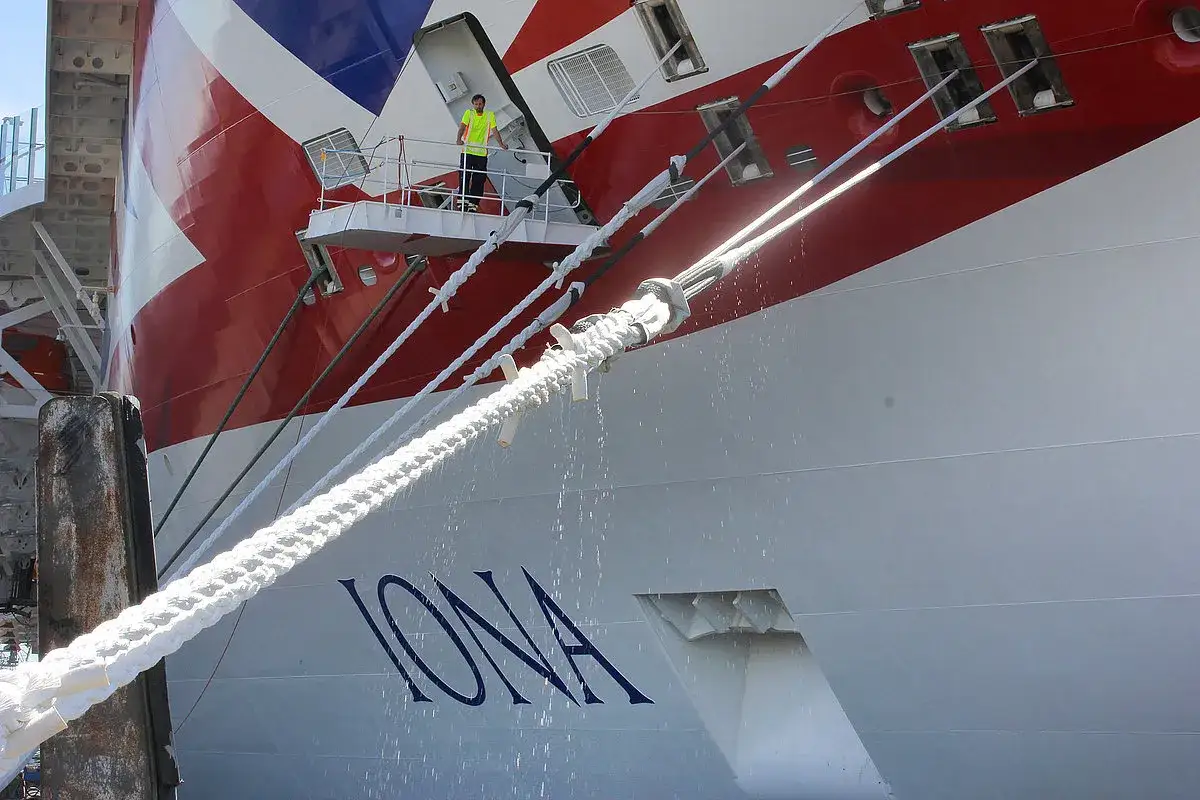 Ein Mann in Warnweste steht auf einem Wartungssteg des **moored ship** 