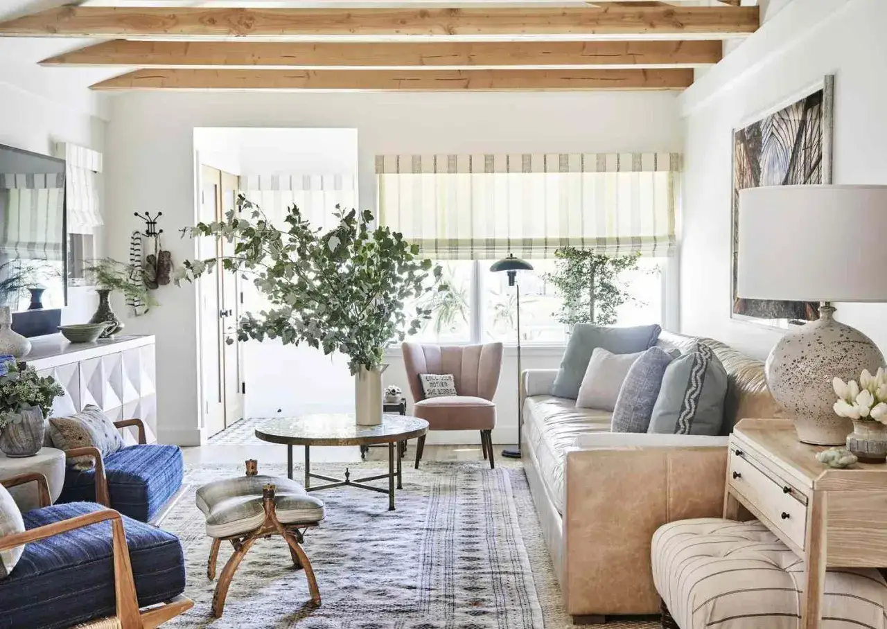 Cozy family room ideas: a light tan sofa, plush blue armchairs, and a round coffee table create a welcoming space.