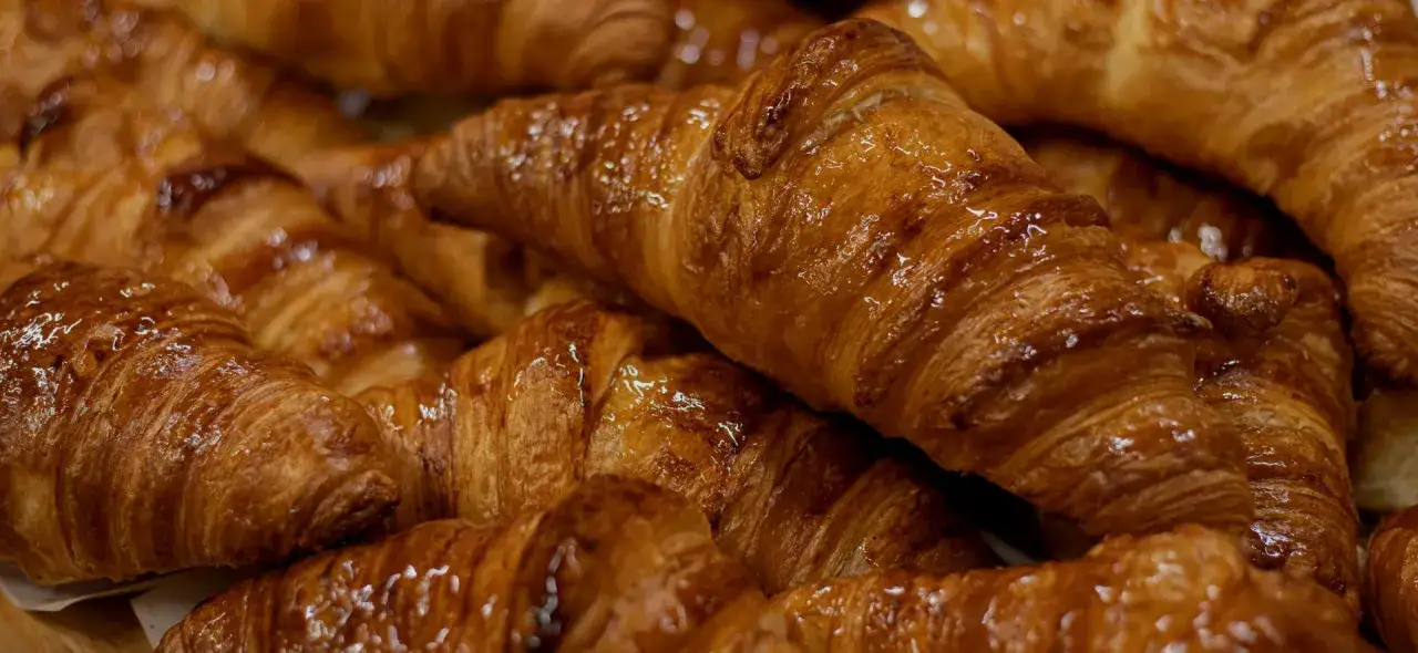 Un montón de croissants dorados y brillantes, un delicioso pan dulce perfecto para el desayuno.