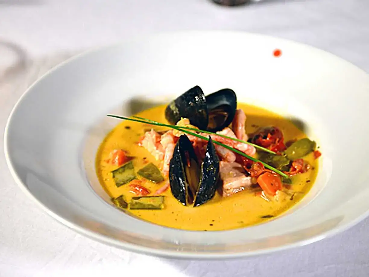 En vacker sk&aring;l med bouillabaisse, fylld med musslor, r&auml;kor och gr&ouml;nsaker i en gyllene buljong. Ett perfekt recept f&ouml;r en lyxig middag.
