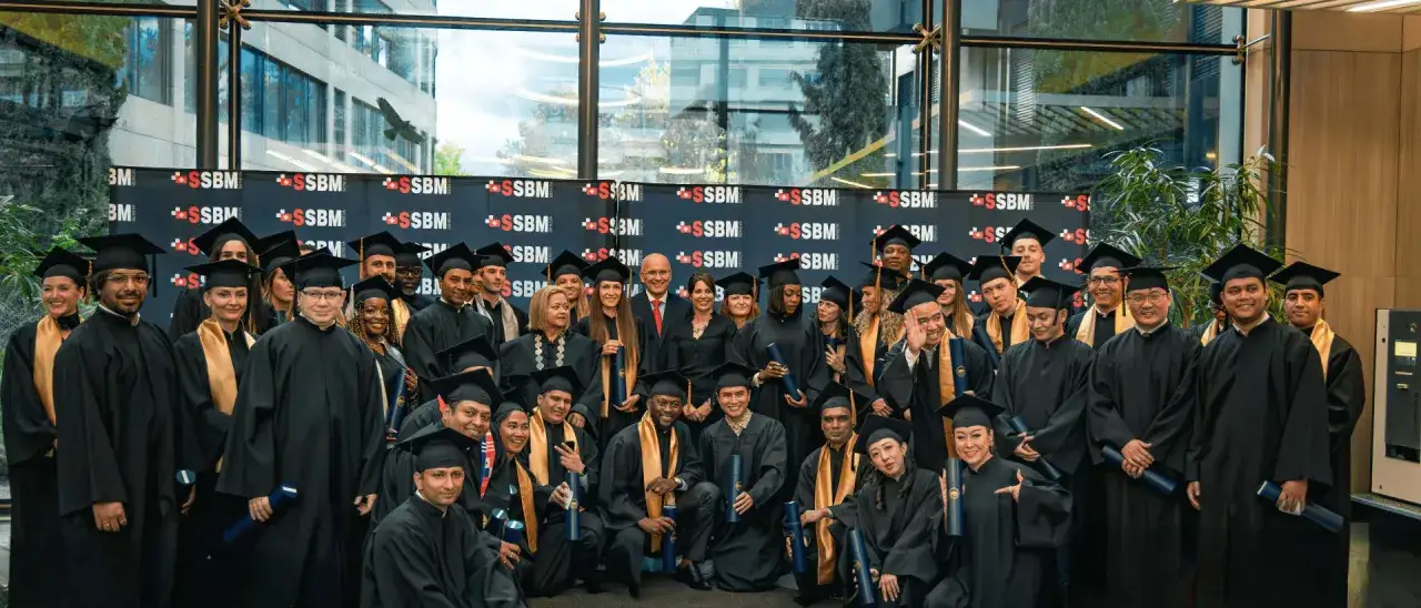 Groupe d'étudiants diplômés en toges noires et chapeaux, célébrant la fin de leurs cours en Suisse.