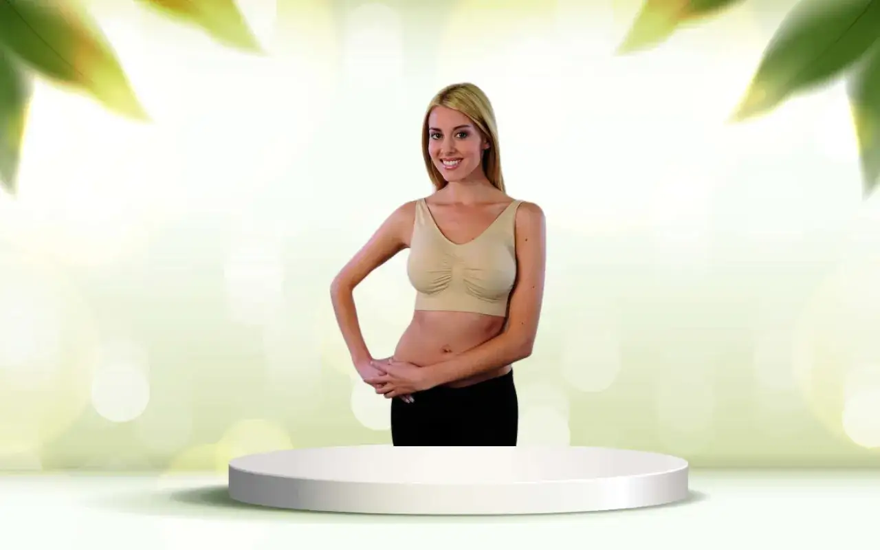 Donna sorridente con tette e reggiseno beige, in piedi su un piedistallo bianco.