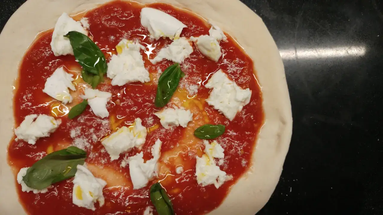 Niegotowa pizza Margherita, z sosem pomidorowym, mozzarellą i bazylią. Takie smaki narodziły się tam, gdzie powstała pizza – we Włoszech.