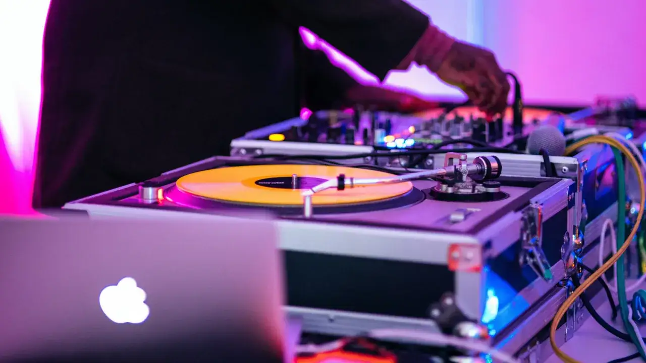 DJ miksuje muzykę na gramofonie z żółtą płytą. To pierwszy krok, jak zostać DJ-em.