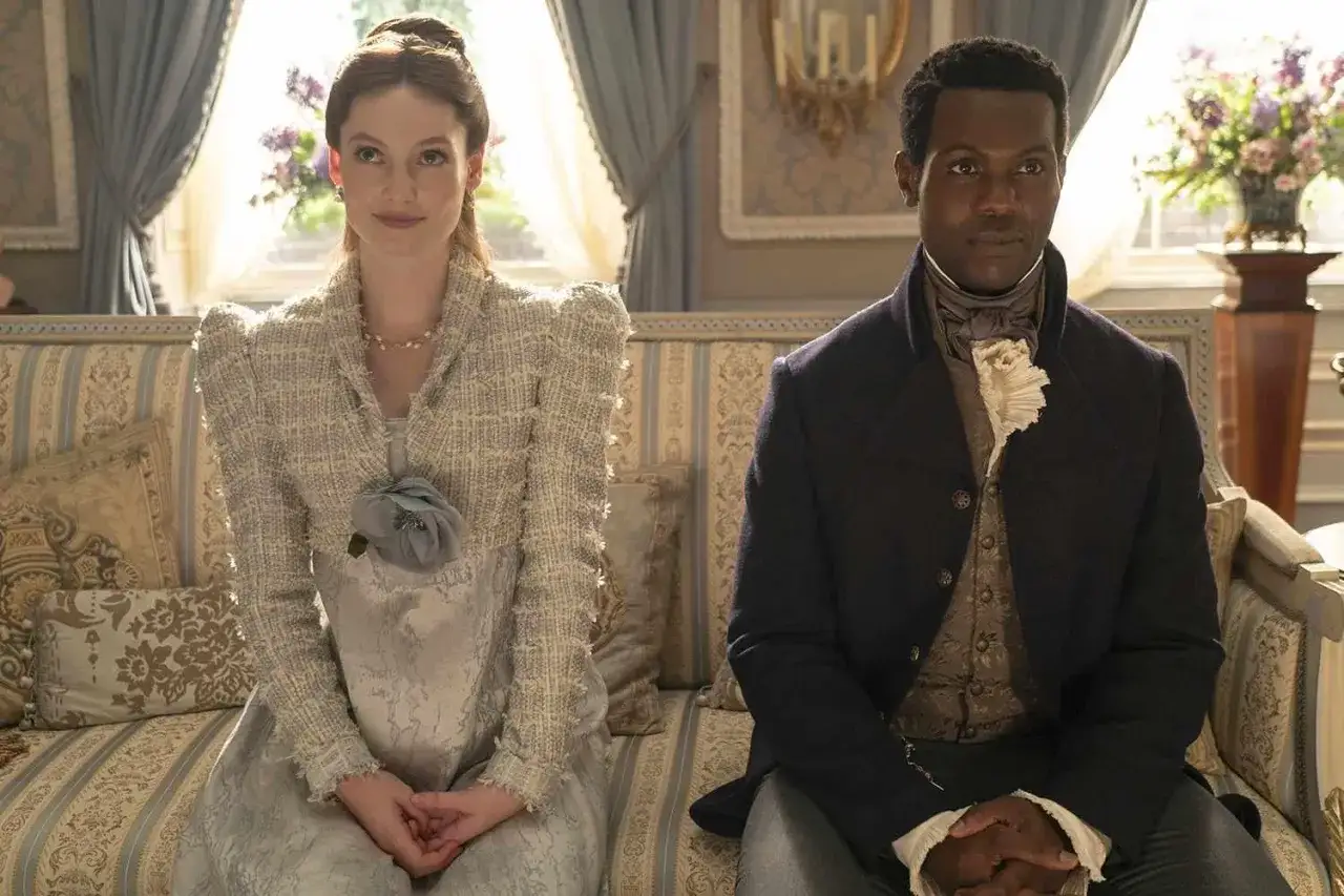 Francesca Bridgerton och en man sitter på en soffa i en elegant salong.