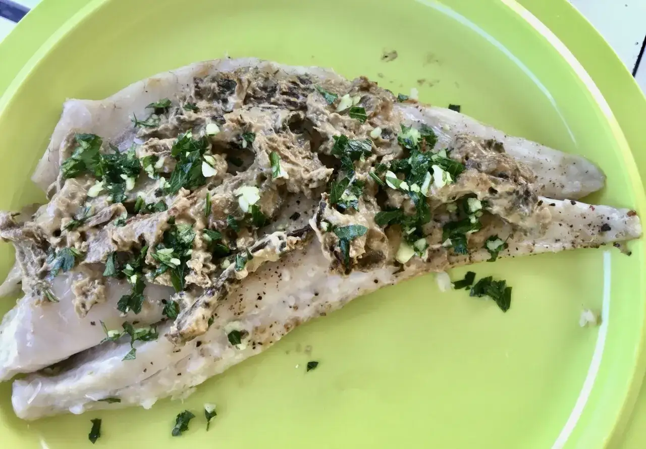 Filet de maigre au four, garni d'une sauce crémeuse aux champignons et persil frais. Parfait pour un repas rapide, le temps de cuisson est idéal.