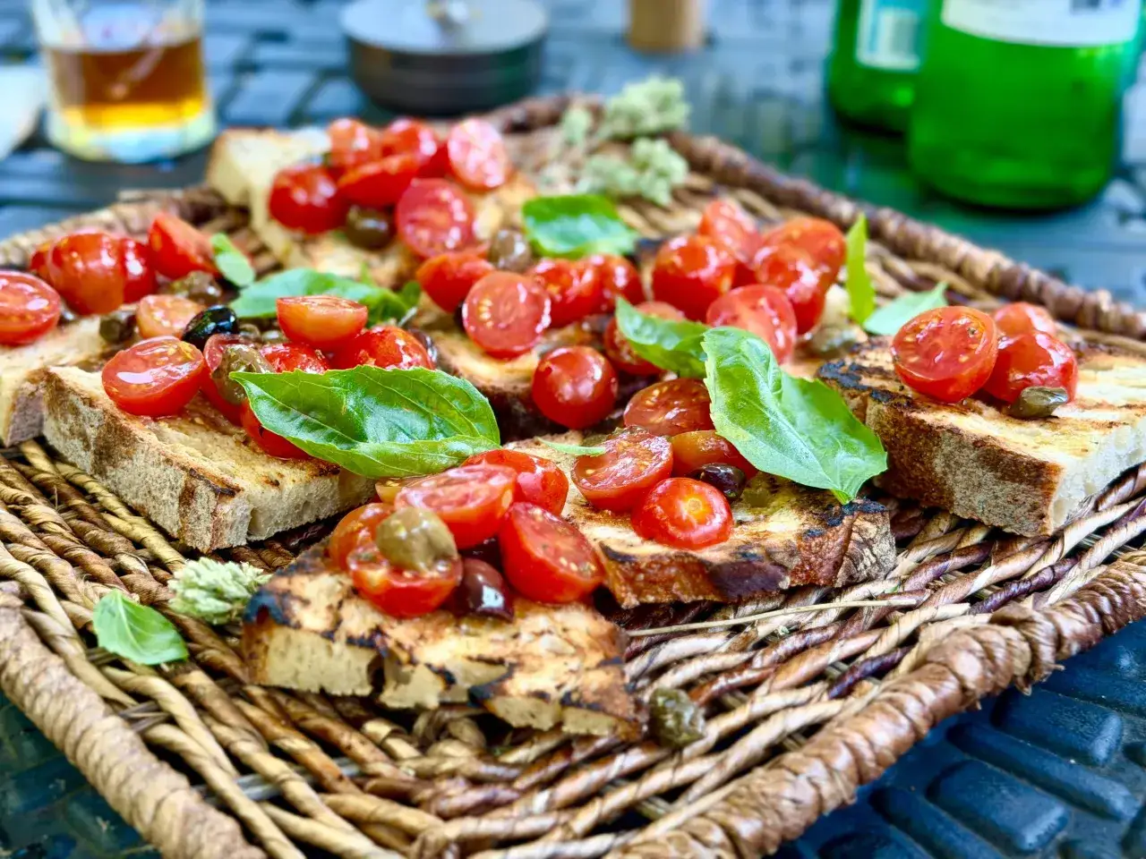 Ein köstliches **Rezept Bruschetta original italienisch**: geröstetes Brot mit frischen Tomaten, Oliven und Basilikum auf einem rustikalen Korb.