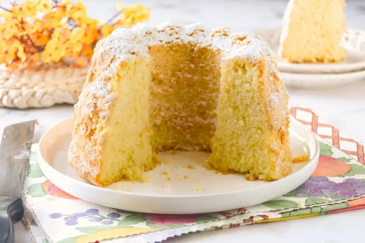 Un bollo maimón esponjoso, espolvoreado con azúcar glas, descansa en un plato blanco.