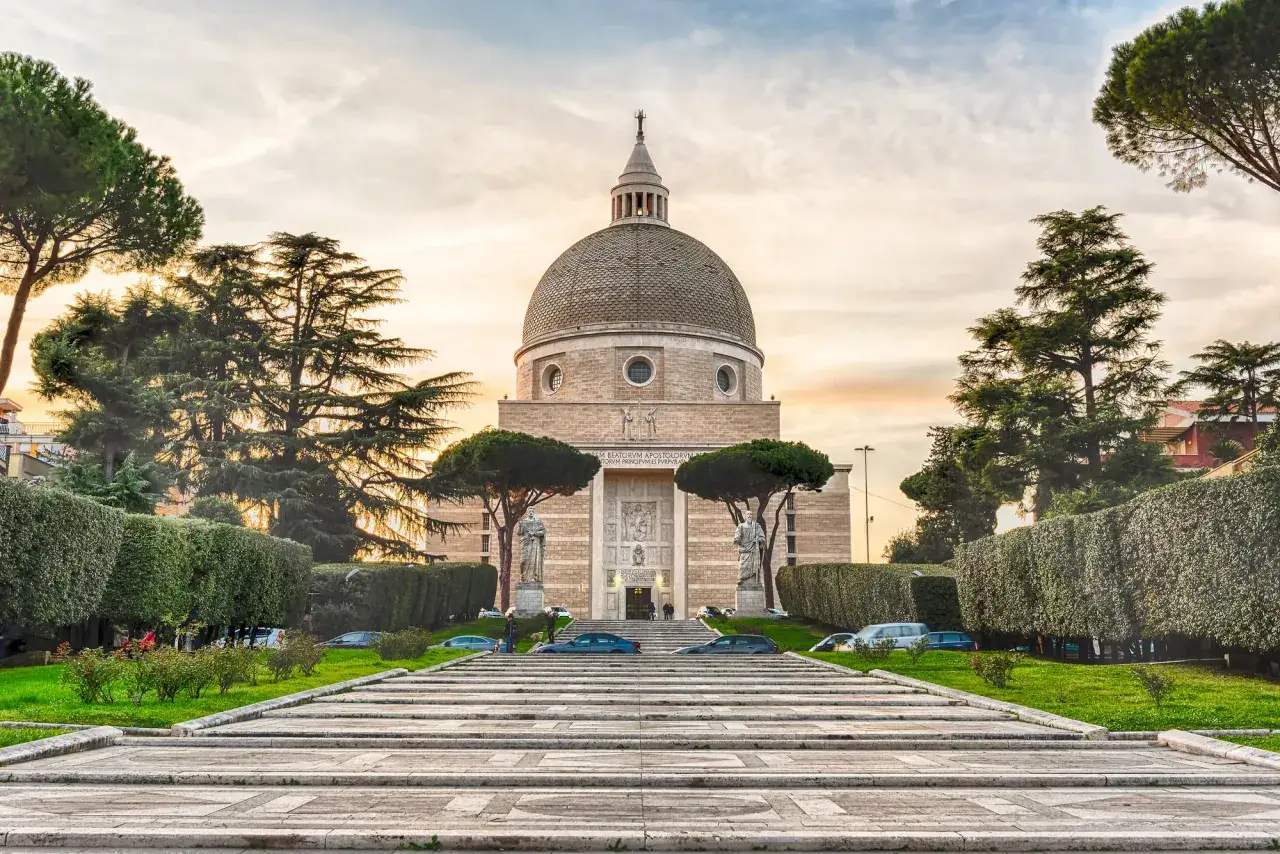 Imponente cupola della chiesa di San Pietro e Paolo, con scalinata in pietra e alberi curati.