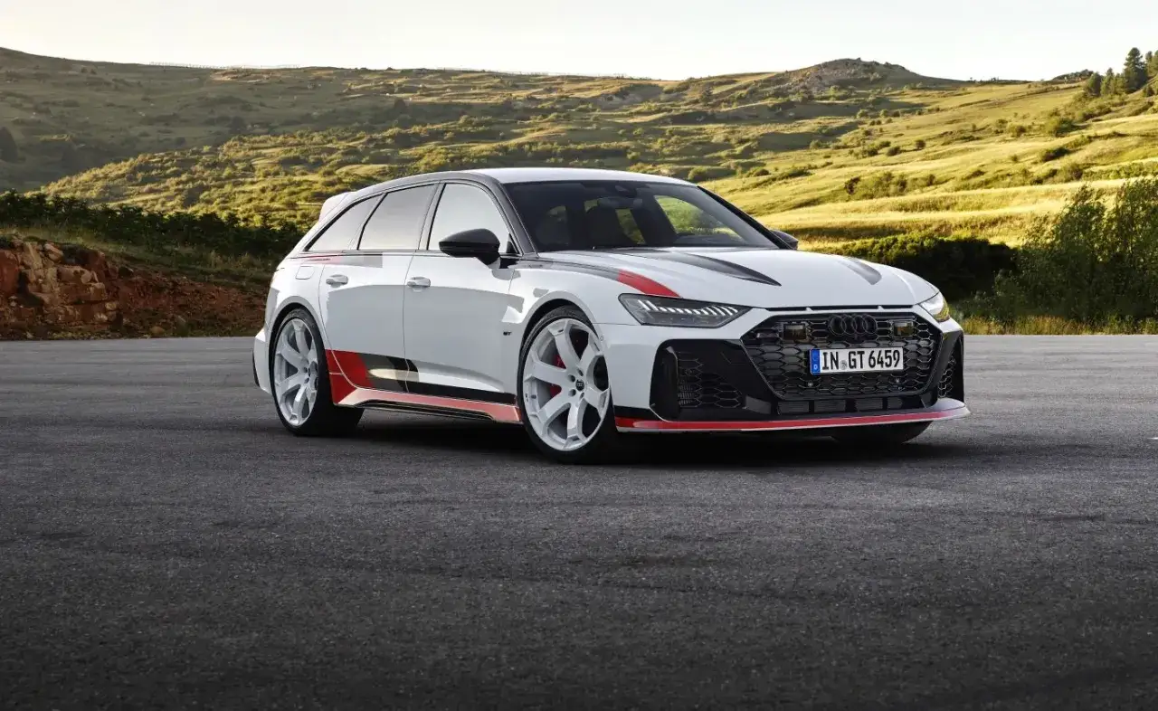 Białe Audi RS6 z czerwonymi akcentami na tle górskiego krajobrazu. Sprawdź aktualną audi rs6 cena.