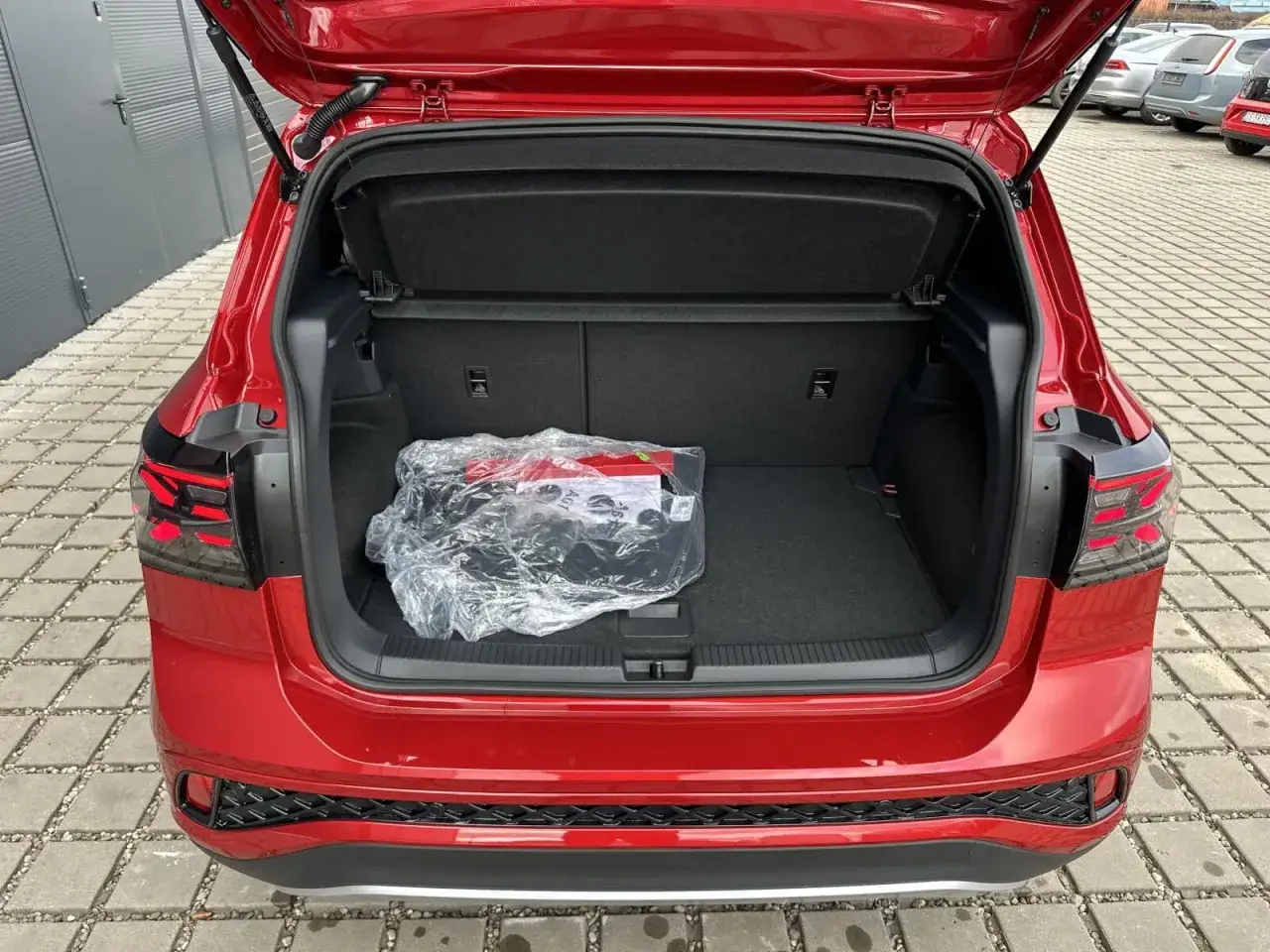 Bagażnik czerwonego VW T-Cross z folią i apteczką. Gotowy na podróż!