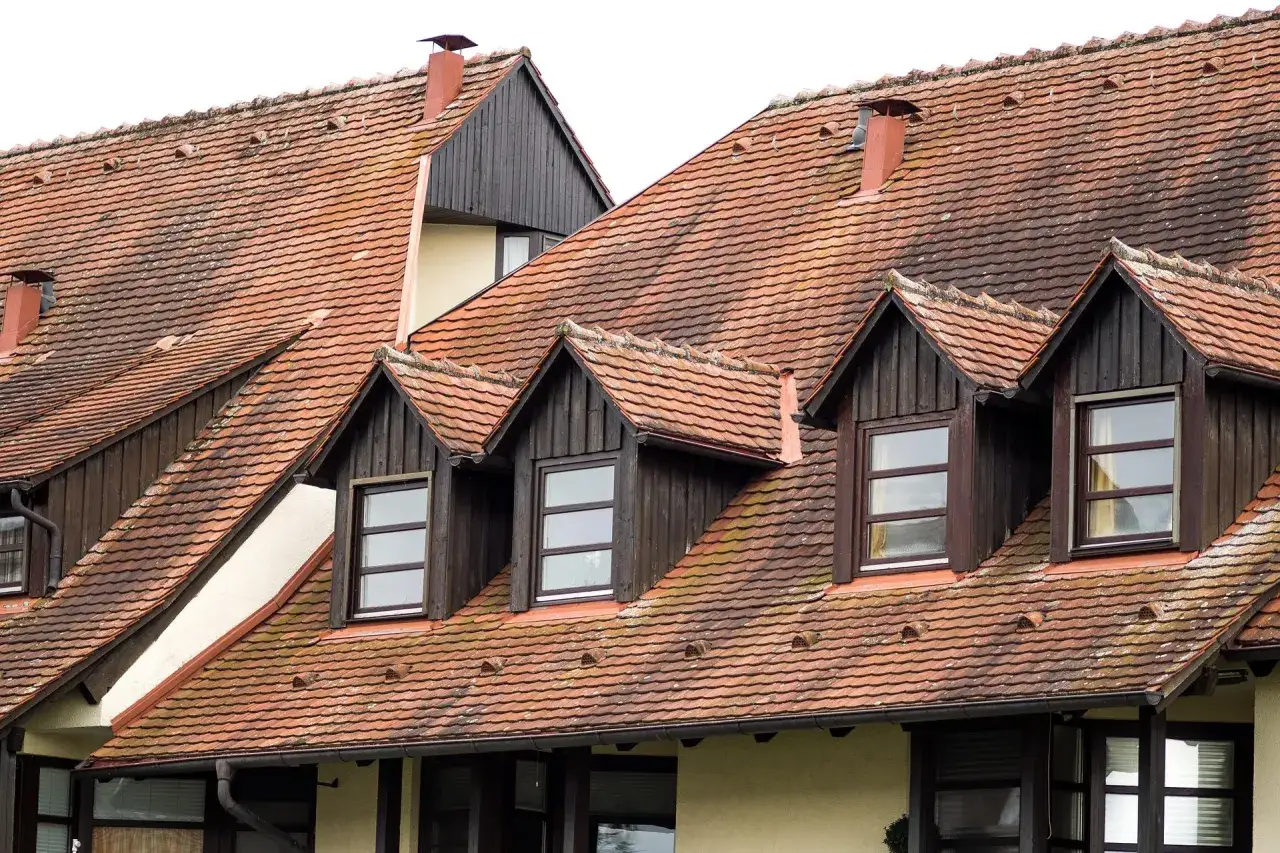 Dachówki dachowe pokrywają dach z kilkoma lukarnami dachowymi, które dodają charakteru budynkowi.