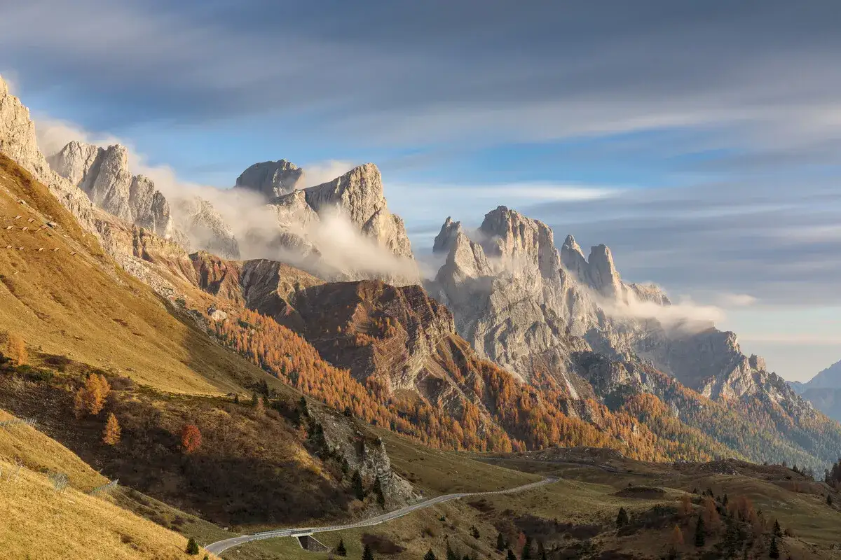 Herbstliche Dolomiten: goldene H&auml;nge, zerkl&uuml;ftete Gipfel und Nebelschwaden. Ein Traumziel f&uuml;r Dolomiten Wandern Highlights.