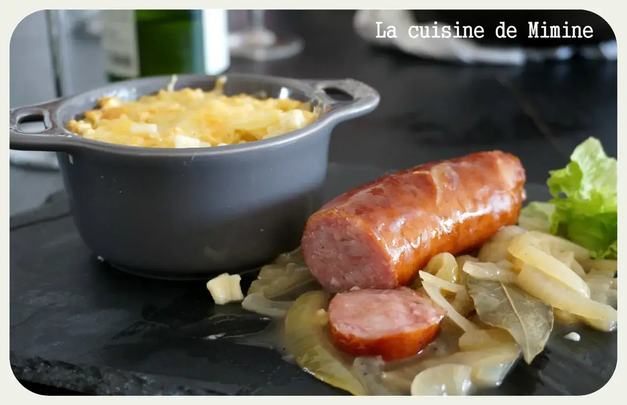 Un gratin de crozet diot, plat savoyard réconfortant, servi avec une saucisse et des oignons fondants.