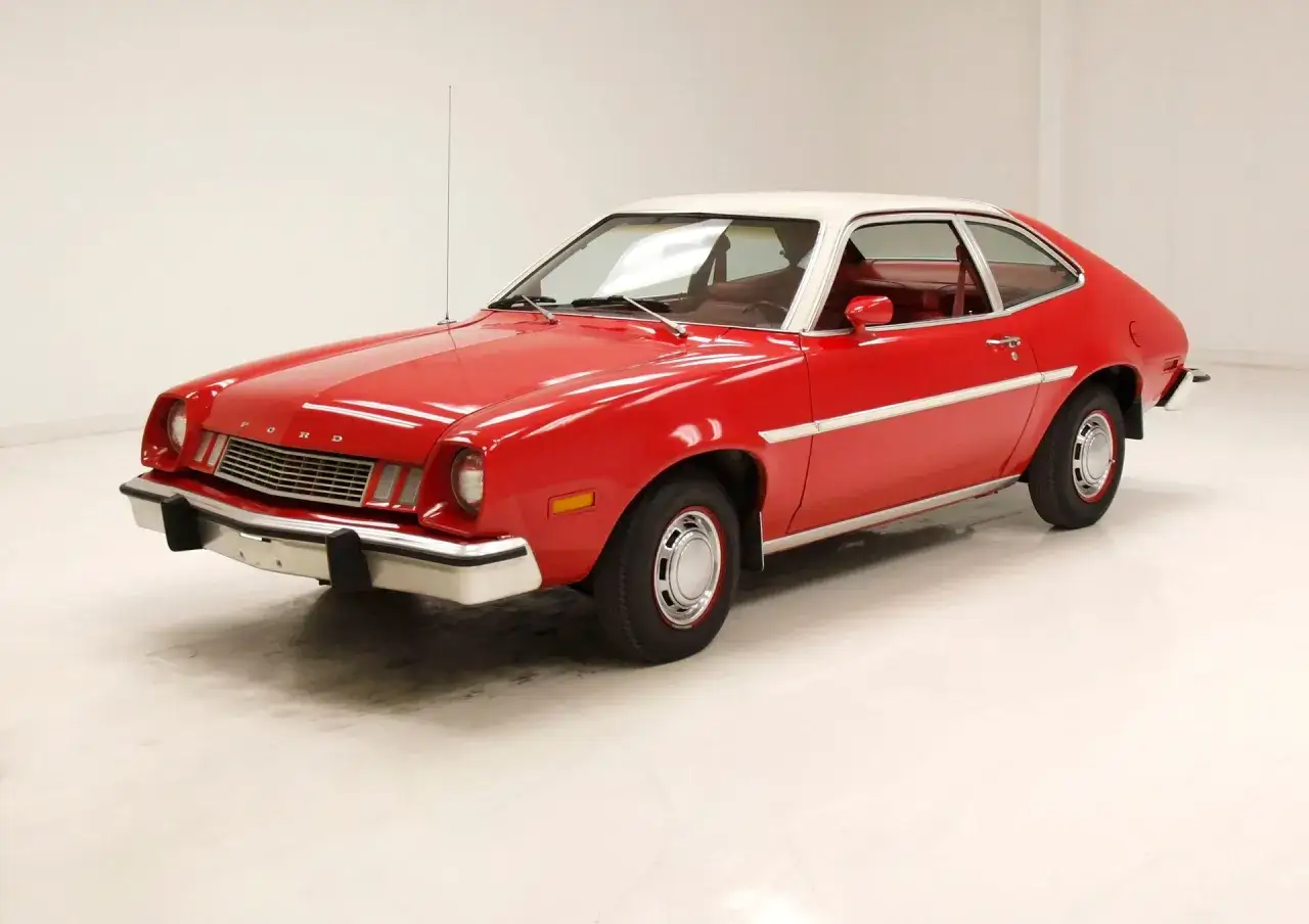 Czerwony Ford Pinto z białym dachem, klasyk z lat 70., błyszczy na białym tle.