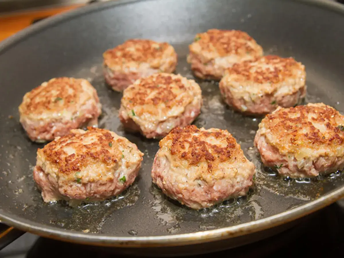 Sieben goldbraun gebratene Buletten in einer Pfanne. Ein leckeres Buletten Rezept, das Appetit macht.