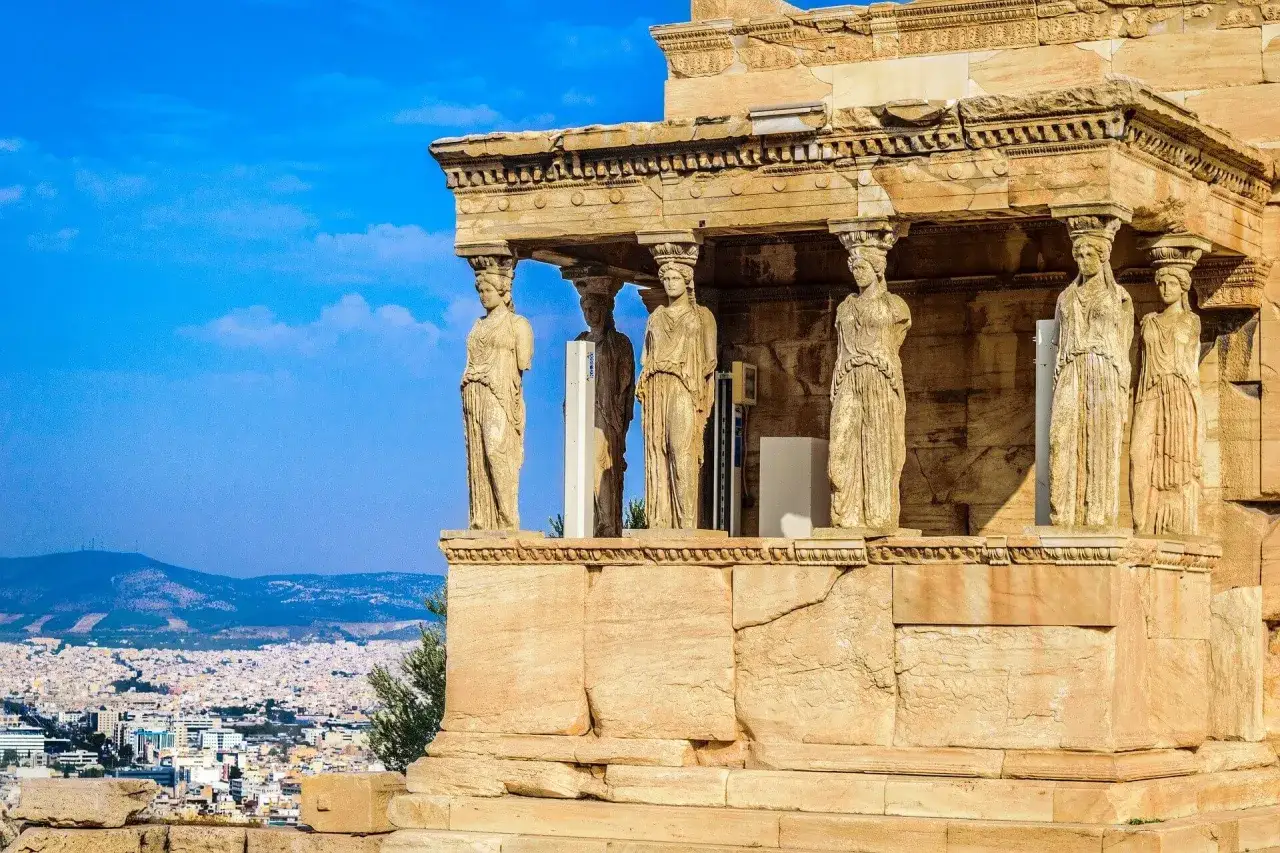 Las Cariátides del Erecteión, un tesoro que ver en Grecia en una semana, vigilan Atenas.