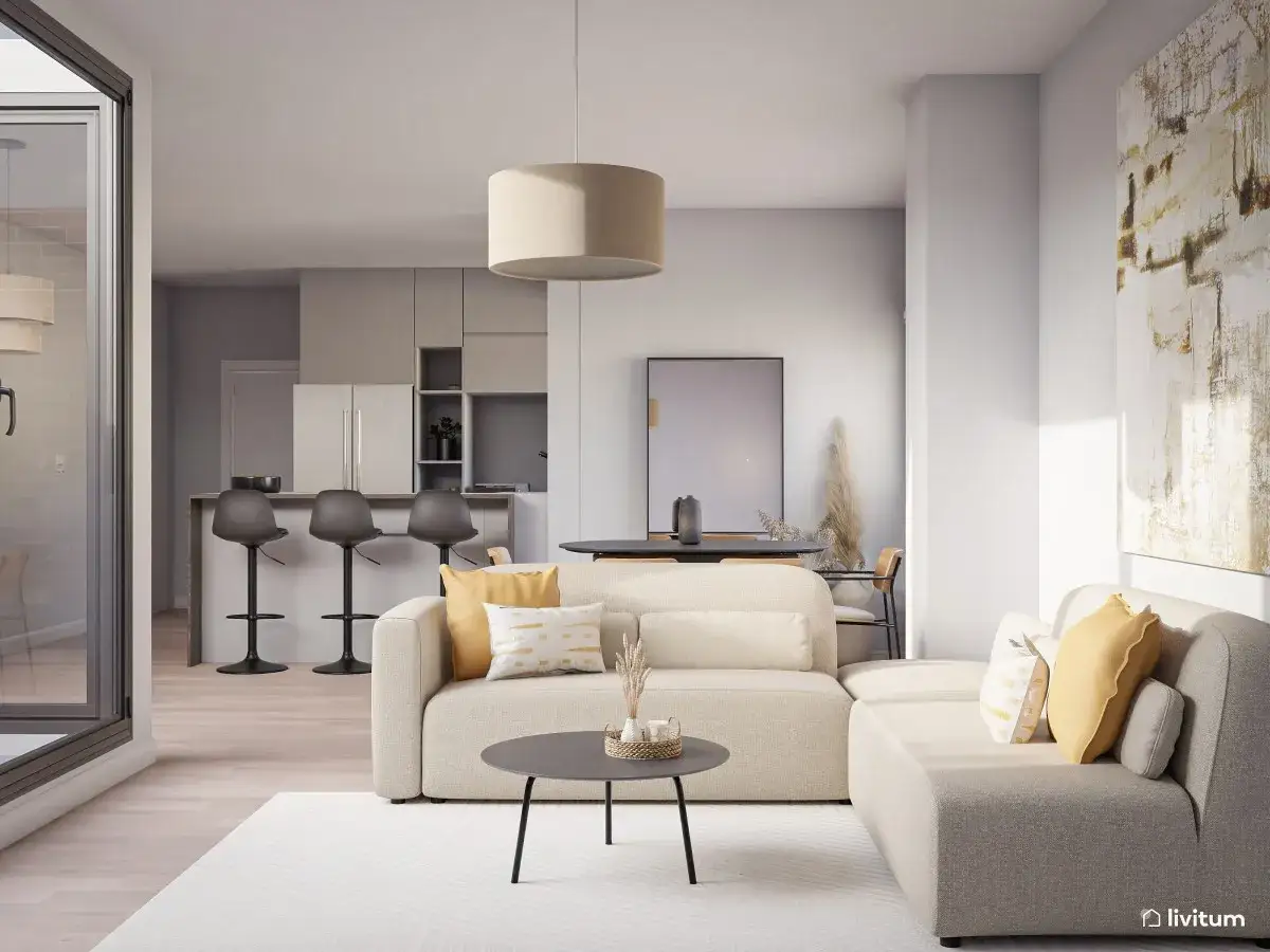 Sofá modular beige, mesa de centro, cocina con barra y taburetes. Un cuadro abstracto y plantas secas añaden un toque de **ruido visual** a este espacio moderno.