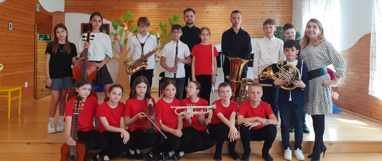Dzieci wesoło wybiegły ze szkoły, gotowe do występu z instrumentami: skrzypcami, gitarą, saksofonem, klarnetem i tubą.