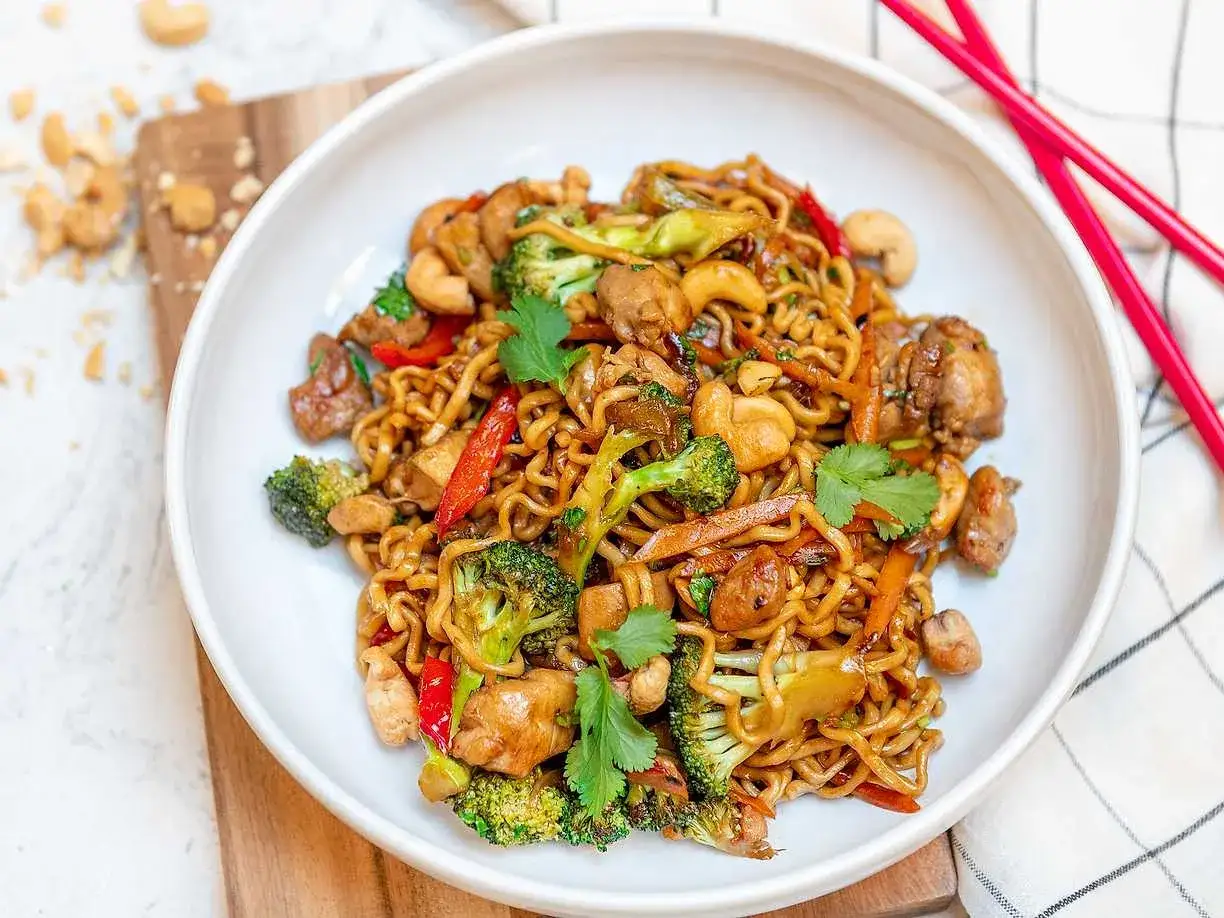 En skål med nudlar, kyckling, broccoli, paprika och cashewnötter. Ett perfekt nudlar recept för en snabb och god middag.