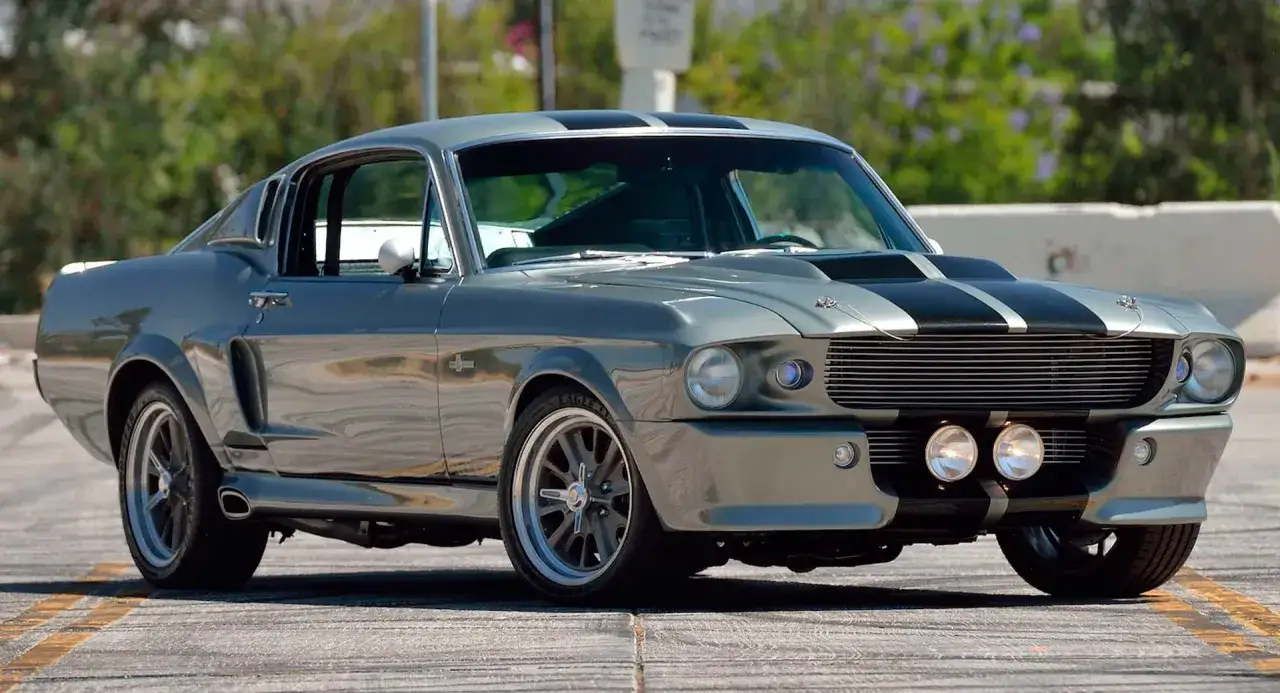 Ikoniczny mustang Eleanor w szarym kolorze z czarnymi pasami, gotowy do akcji.