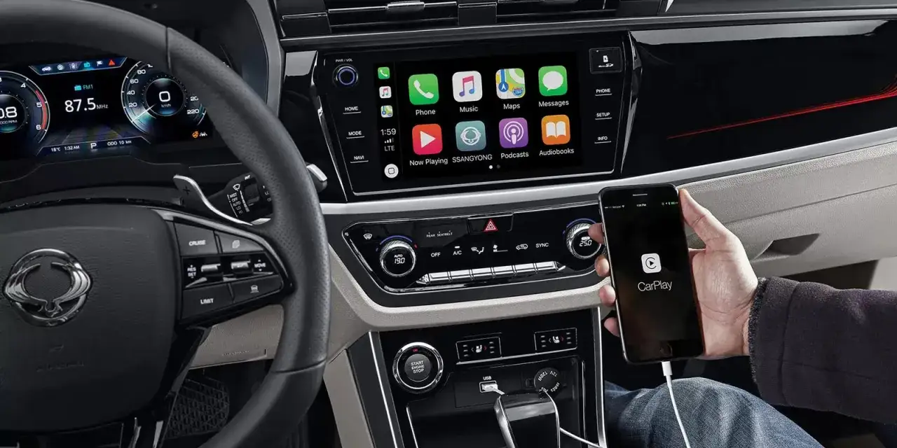 Wnętrze SsangYong Korando z ekranem dotykowym i podłączonym telefonem z CarPlay.