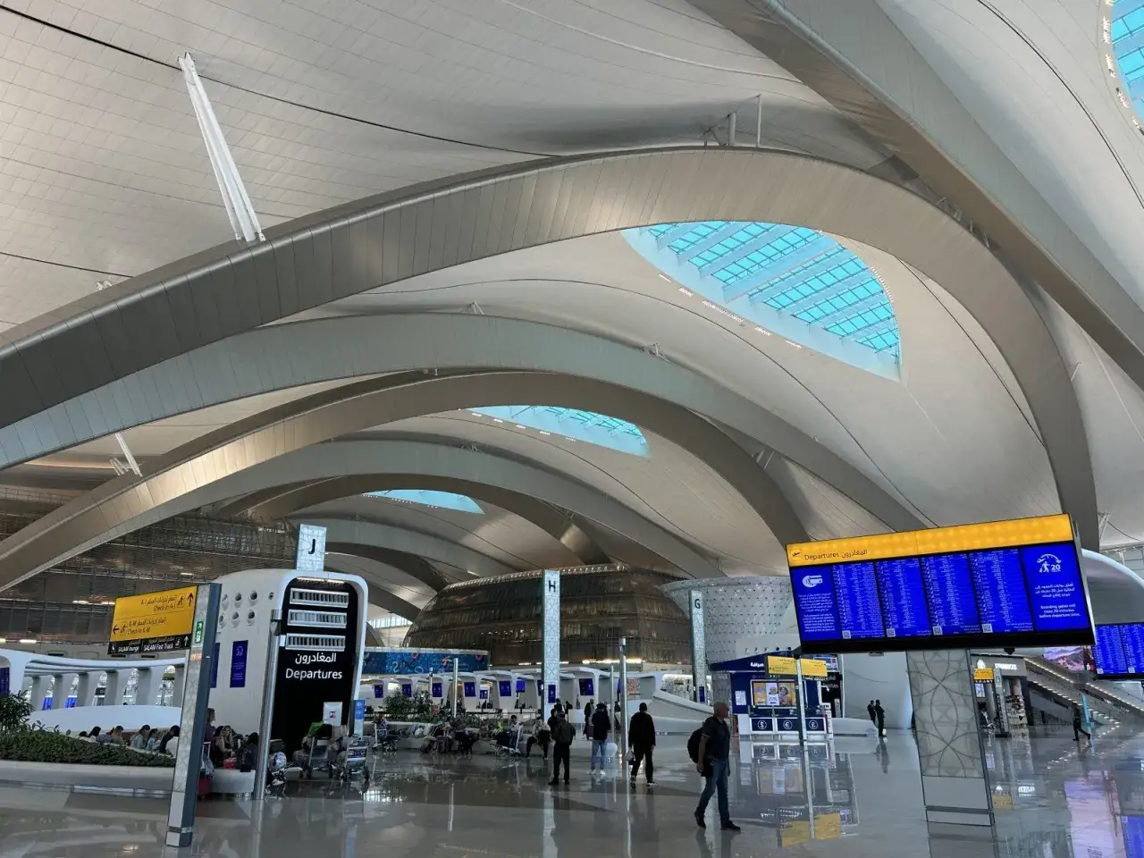 Nowoczesne lotnisko w Abu Zabi, z futurystycznym dachem i tablicami odlotów. Czekam na moje abu dhabi loty.