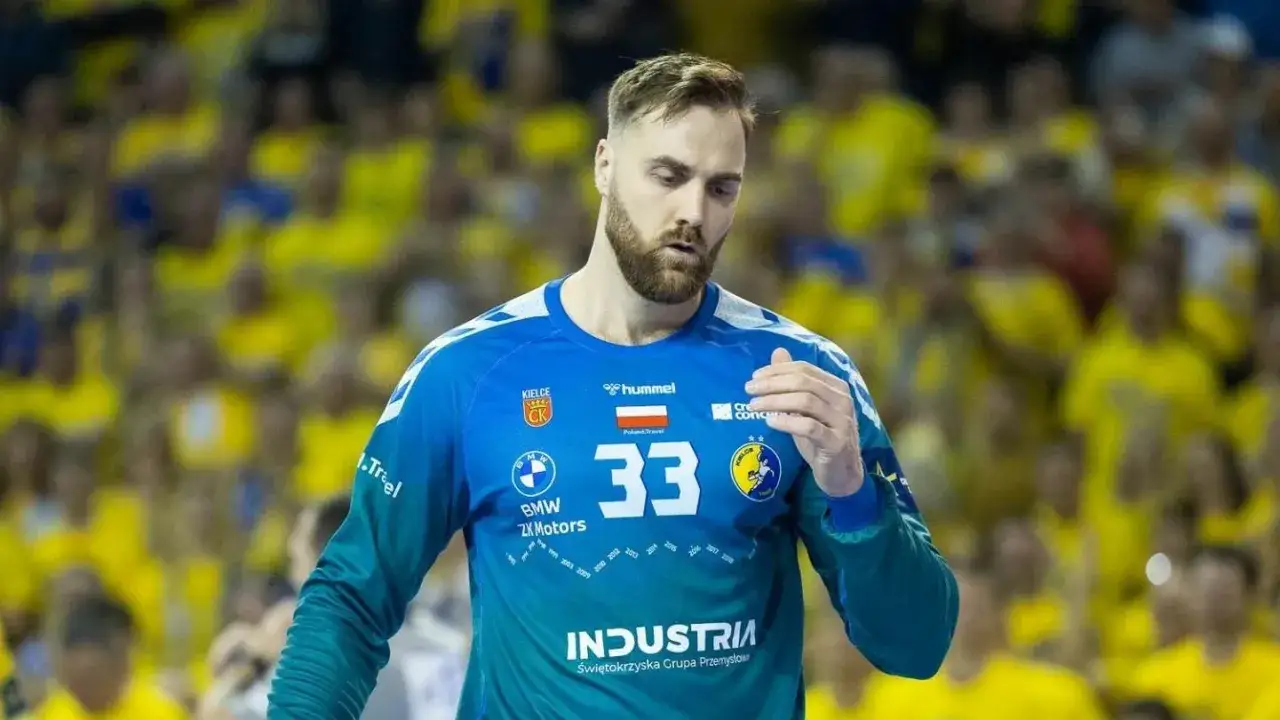 Andreas Wolf, zawodnik z numerem 33 na niebieskiej koszulce, na tle żółtej publiczności.